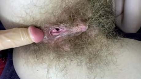 Hairy girl fucks her wet big clit pussy with dildo in close up